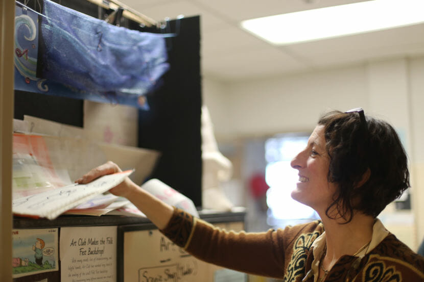 JDHS Art Club advisor Heather Ridgeway with the display model created by the JDHS Art Club who created the 2018 Alaska Folk Festival backdrop. (Photo by Annie Bartholomew/KTOO)