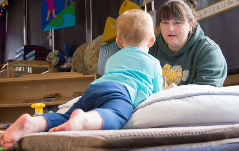 Gretchen Boone flips through a picture book for an infant at the Gold Creek Child Development Center in Juneau on May 11, 2018. Boone is the center's director.