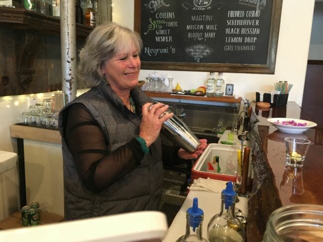 Janilyn Heger mixes a cocktail at Skagway Spirits distillery. (Photo by Abbey Collins/KHNS)
