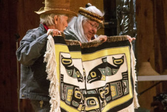 Nathan Jackson, left, and Della Cheney hold up a blanket made by Dorica Jackson during a weavers' presentation at the Shuka Hit clan house at the Walter Soboleff Building in downtown Juneau on June 6, 2018.