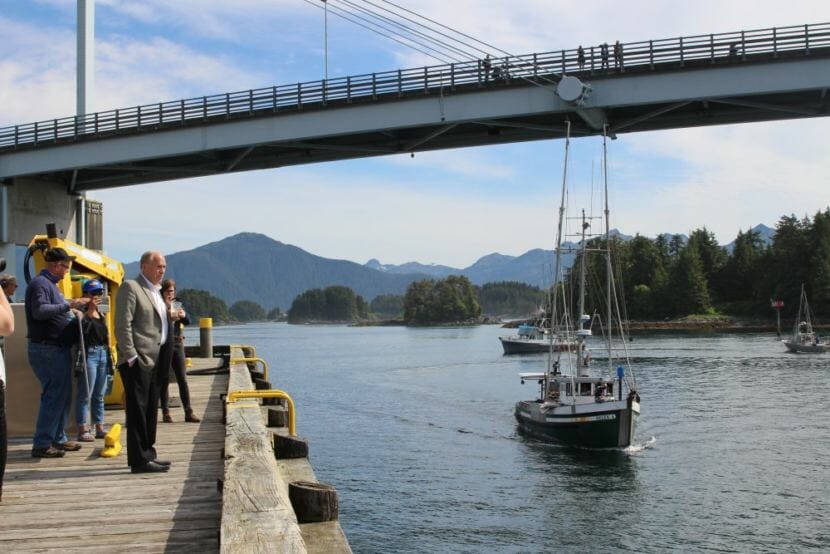 Alaska Gov. Bill Walker looks out over Sitka Sound, as trollers pass by calling for him to not sign a Pacific Salmon Treaty that would further cut Alaska’s allocation. The salmon fleet organized a boat parade and rally to send that message. (Photo by Emily Kwong/KCAW)