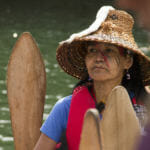 A woman waits in her canoe on Tuesday, June 5, 2018, in Douglas Harbor.