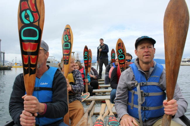 Jim Kindle (left) and John Hannon (right) sit with other members of One People Canoe Society in the Eagle canoe during a supply run on Tuesday, May 29, 2018. (Photo by Adelyn Baxter/KTOO)