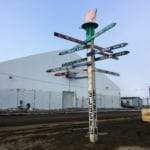A mile post close to the airport in Utqiaġvik. It's one of many visible ways that the transition from the name 'Barrow,' is still ongoing. (Photo by Ravenna Koenig/ Alaska's Energy Desk.)