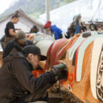 Traditional Arts Apprentice & Youth Mentor Shane Brown works on the Yanyeidí totem pole at Harborview Elementary School on May 29, 2018. (Photo by Annie Bartholomew/KTOO)
