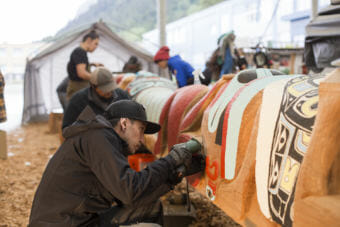 Traditional Arts Apprentice & Youth Mentor Shane Brown works on the Yanyeidí totem pole at Harborview Elementary School on May 29, 2018. (Photo by Annie Bartholomew/KTOO)