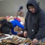 Sam Sheakley selects his tool while carving a totem Harborview Elementary School on May 29, 2018. (Photo by Annie Bartholomew/KTOO)