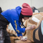 Indigenous artist Merritt Johnson paints Yanyeidí totem pole at Harborview Elementary School on May 29, 2018. (Photo by Annie Bartholomew/KTOO)