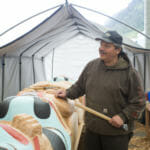 Master carver Will Burkhart helps finish the totem in the final days of production at Harborview Elementary School on May 29, 2018. (Photo by Annie Bartholomew/KTOO)