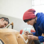 Indigenous artist Merritt Johnson works alongside her partner Nicholas Galanin painting the 40 foot Yanyeidí totem pole at Harborview Elementary School on May 29, 2018. (Photo by Annie Bartholomew/KTOO)