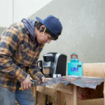 Apprentice carver Lee Burkhart cuts a two by three foot traditional copper shield or Tináa to be fitted on the totem at Harborview Elementary School on May 29, 2018. (Photo by Annie Bartholomew)