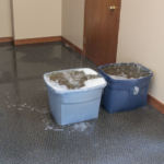 Water from a 3rd floor fire rains into buckets, already in place from prior leaks, in the ASEA/PSEA offices on the 1st floor of the Mendenhall Towers on Thursday July 5th, 2018 (Photo by Mikko Wilson/KTOO)
