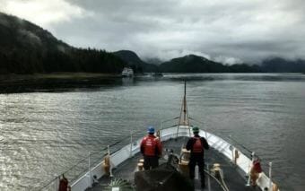 In this photo taken from the deck of the Anacapa, the Allen Marine tour vessel St. Eugene is seen offloading passengers from the Alaskan Dream, which is aground on a beach in Olga Strait. None of the Dream’s 43 passengers or 10 crew members were injured in the incident. (Photo courtesy U.S. Coast Guard)