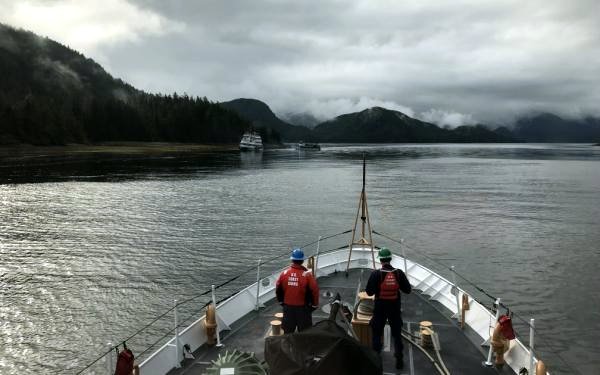 In this photo taken from the deck of the Anacapa, the Allen Marine tour vessel St. Eugene is seen offloading passengers from the Alaskan Dream, which is aground on a beach in Olga Strait. None of the Dream’s 43 passengers or 10 crew members were injured in the incident. (Photo courtesy U.S. Coast Guard)