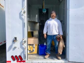 Savoonga’s chief reindeer herder Richmond Toolie, at the mobile reindeer processing plant (Photo by Gabe Colombo/KNOM)