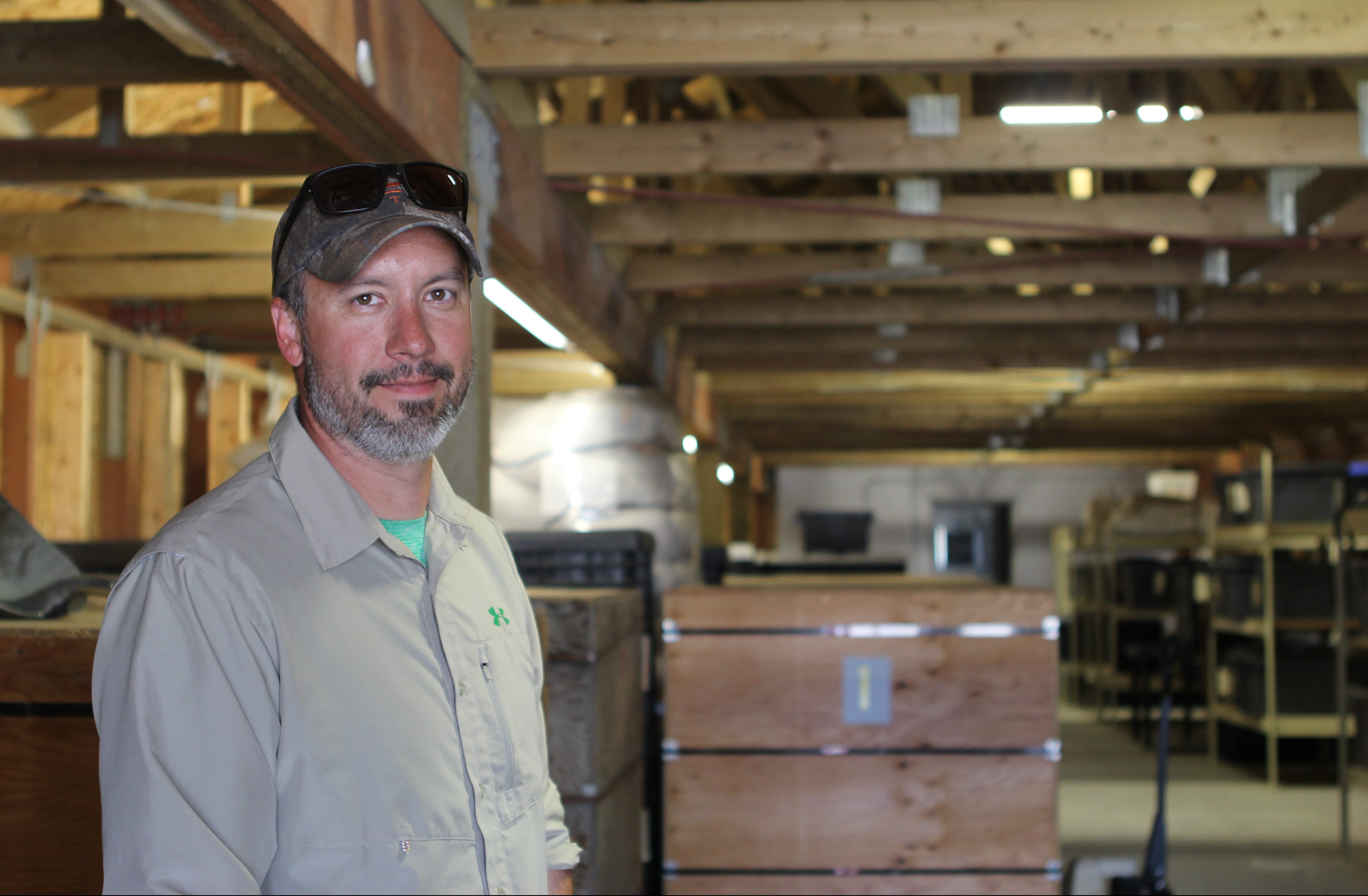 Rob Carter stands next to bins of wheat and barley at the Alaska Plant Materials Center outside of Palmer. He’s the managing agronomist and the head of Alaska’s soon-to-be industrial hemp pilot program. (Photo by Erin McKinstry/Alaska Public Media)