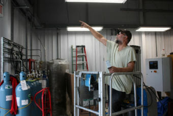 Electrician Joel Elson points out features of Togiak's new power plant on Aug. 3, 2018. (Photo by Austin Fast/KDLG)