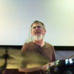 Clae Good plays drums for a Juneau set with the Amish Robots, now known as Revilla at the KXLL Showcase during the 2018 Alaska Folk Festival. (Photo by Annie Bartholomew/KTOO)