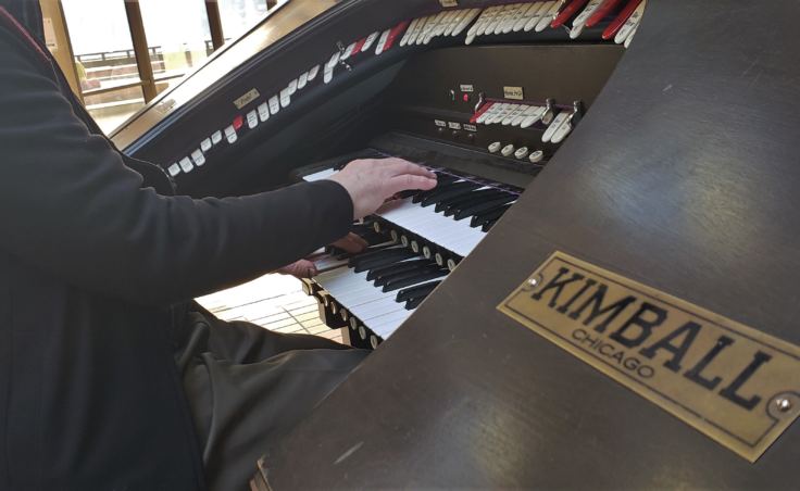 J. Allan MacKinnon plays Kimball organ in the atrium of the State Office Building in Juneau on Friday, Oct. 26, 2018. He's one of a handful of organ players in town who regularly play Friday lunchtime concerts on it.