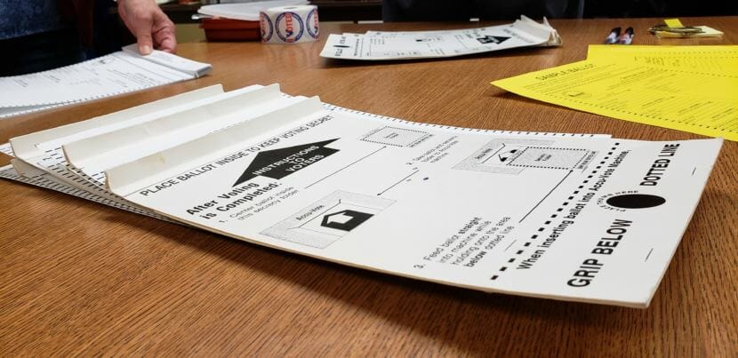 A poll worker at the Juneau Fire Station lays out ballot privacy folders on Oct. 2, 2018, Juneau's municipal Election Day.