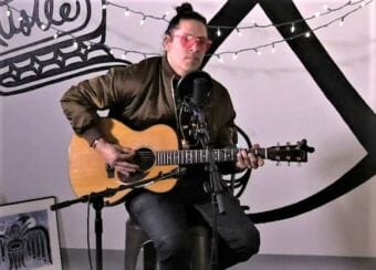 Screen shot of Nicholas Galanin of Indian Agent performing a Red Carpet Concert during Celebration 2018 at Beast Flow Studio in Juneau, AK.