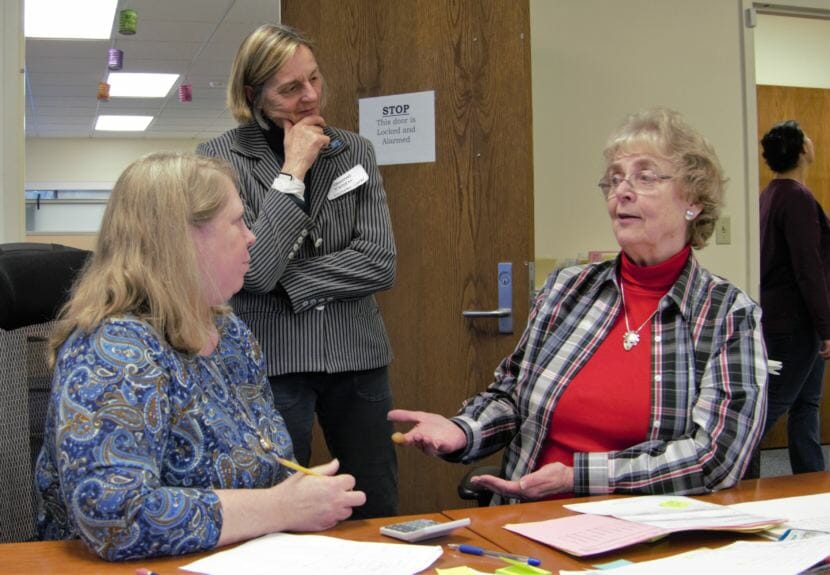 State Review Board member Stuart Sliter discusses part of the election certification process with board member Lynda Thater-Flemmer, seated, and House District 1 candidate Kathryn Dodge, D-Fairbanks, in the Juneau office of the Alaska Division of Elections on Nov. 23, 2018.