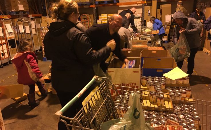 Employees of Super Bear and Foodland fill bags of food for Juneau students on Dec. 19, 2018. (Photo by Zoe Grueskin/KTOO)