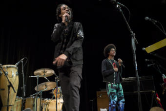 Two men rap into microphones on stage Juneau hip hop duo Chris Talley and Arias Hoyle opened for Khu.éex' at Centennial Hall on Monday, January 28, 2019. The duo released a video for their song "Zibit" in November which honors southeast Alaska's history and culture. (Photo by Annie Bartholomew/KTOO)