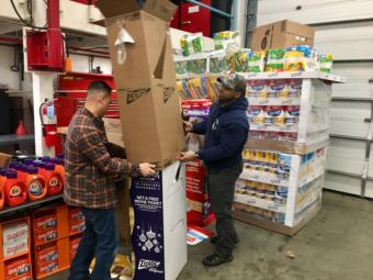 Quy Nguyen (left) and Mahire A'Giza unpack donations at the consumables pantry on Jan. 22, 2019. (Photo by Zoe Grueskin/KTOO)