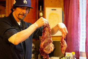 Robert Melovidov holds up fur seal meat that he’s preparing to cook in his home on St. Paul island in January. Unangan people on St. Paul like Melovidov have been pushing the federal government for more than a decade for more freedom to harvest the fur seals they share the island with.