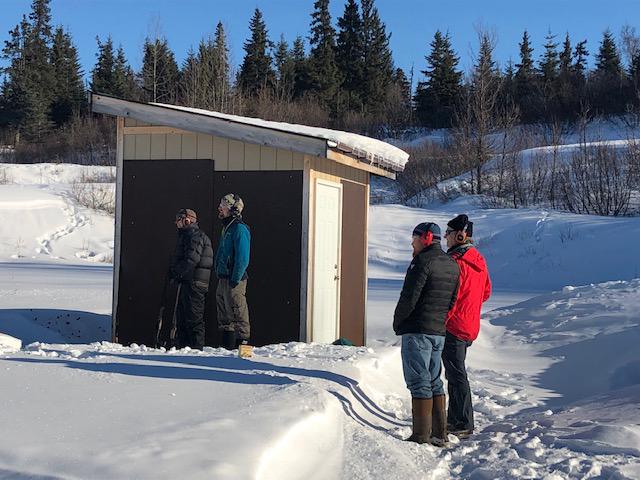 Men wait their turn to shoot at the Kachemak Gun Club and Range.