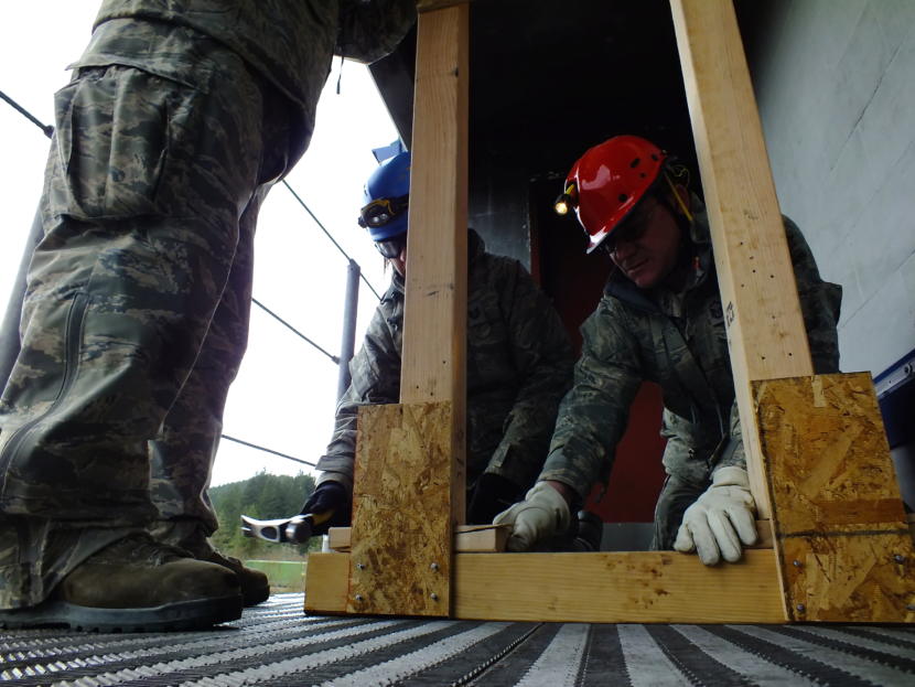 First responders hammer wooden shoring into place to reinforce a damaged building entrance during an urban search and rescue exercise in Juneau on April 12, 2019.