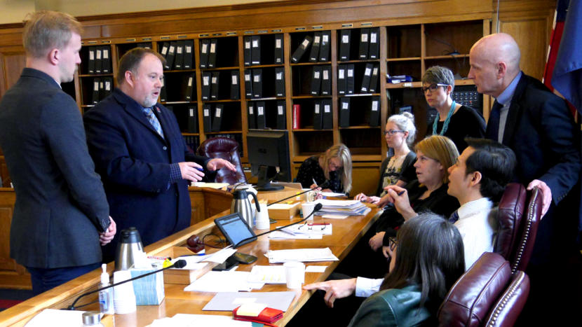Committee aides talk with House Finance Committee members during an at-ease in Juneau on April 4, 2019. The committee was in midst of considering more than 130 amendments to the state operating budget. From left to right: Rep. Neal Foster aides Ryan Johnston and Brodie Anderson; committee staff Jodie McDonnell and Bree Wylie. Standing to the right: Reps, Kelly Merrick, R-Eagle River, and Dan Oritz, I-Ketchikan. Also sitting: Reps. Tammie Wilson, R-North Pole, Neal Foster, D-Nome, and Jennifer Johnston, R-Anchorage.