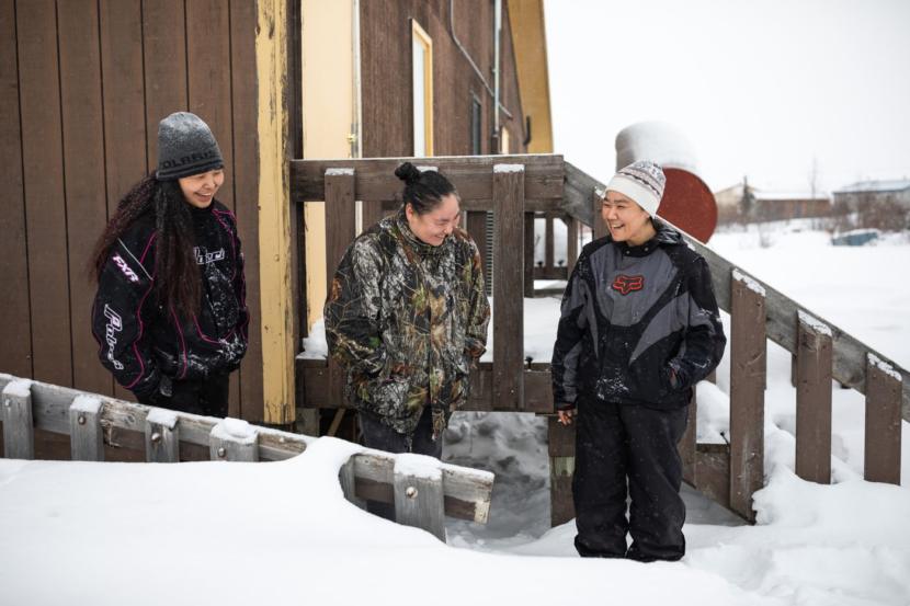 From left, Amber Reed, Pauline Gooden and Clara Stein smoke outside the city office building in Kiana. Stein was taking a break from her job working at the city office.