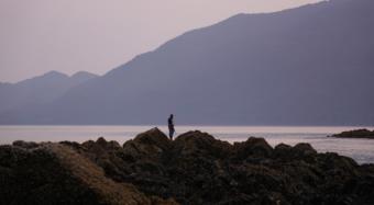 Lyle James scans the waters of Lynn Canal for harbor seals during a hunt early on the morning of June 30, 2019.