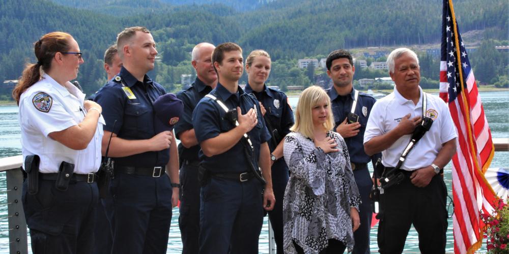 Ashley DeRamus recites the Pledge of Allegiance with members of Capital City Fire/Rescue. (Photo by Adelyn Baxter/KTOO)