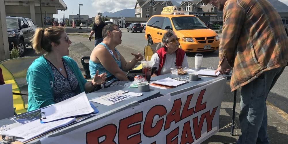 Recall Dunleavy volunteers Frankie Urquhart, left, Jessie Chapman and Pat Chapman gather signatures on Aug. 1 in downtown Ketchikan for a petition to remove Gov. Mike Dunleavy from office. (Photo by Elizabeth Gabriel/KRBD)