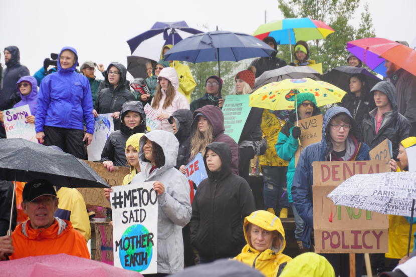 Participants in the Sept. 20 Climate Strike hold signs and listen to speeches at Cuddy Park in midtown Anchorage.