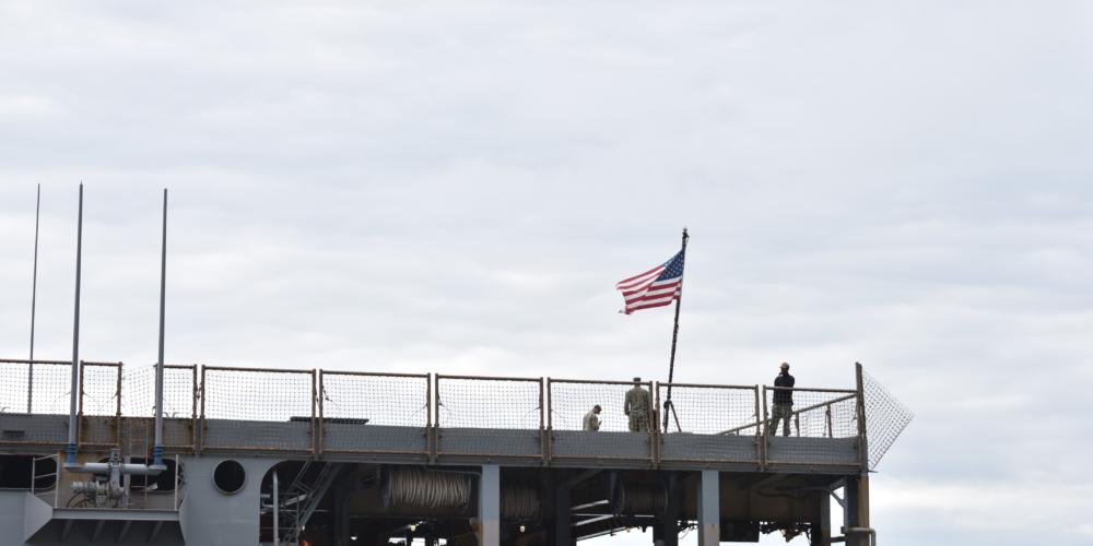U.S. Navy personnel stand on the flight deck of the USS Comstock, docked in Kodiak, Sept. 10, 2019.