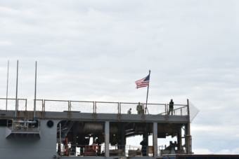 U.S. Navy personnel stand on the flight deck of the USS Comstock, docked in Kodiak, Sept. 10, 2019.