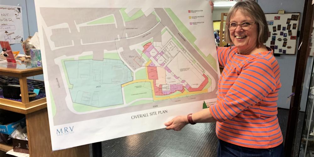 Juneau Arts and Humanities Council Executive Director Nancy DeCherney holds an aerial view of the design for the New JACC. (Photo by Adelyn Baxter/KTOO)