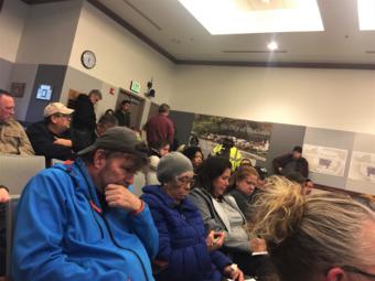A group of people are seated at a community meeting.