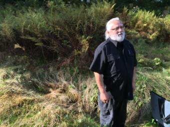 Kahdushan Michael Dunlap stands in front of his great-grandfather's grave in a cemetery on Douglas on Sep. 28, 2019. (Photo by Zoe Grueskin/KTOO)