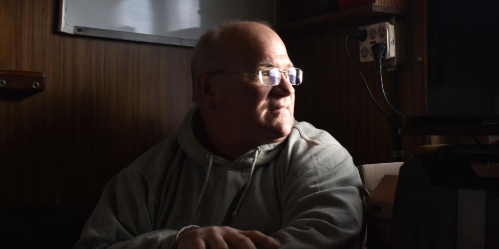 Miles sits in the galley of his boat, the Sumner Strait. (Photo by Kavitha George/Alaska’s Energy Desk)