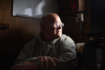 Miles sits in the galley of his boat, the Sumner Strait. (Photo by Kavitha George/Alaska’s Energy Desk)