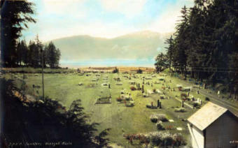 This hand-tinted photograph shows a cemetery in Wrangell circa 1930.