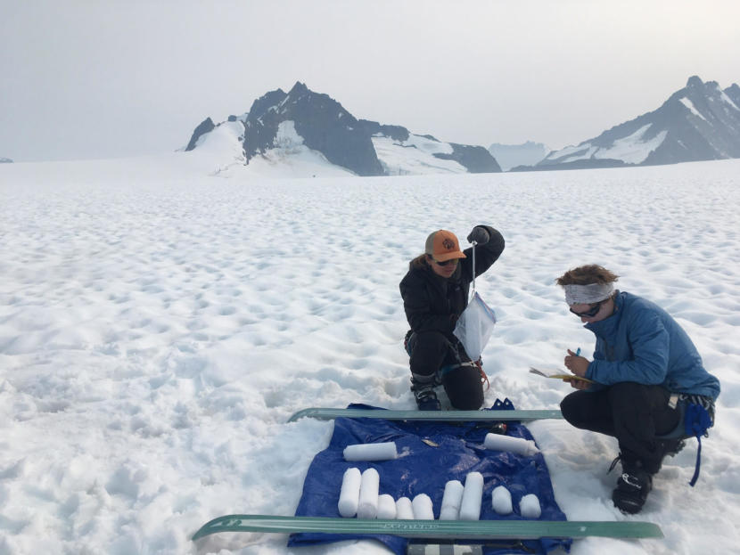 Students Stacey Edmonsond (left) and Audrey Erickson (right) of the Juneau Icefield Research Program, measure glacier mass balance at the flow divide of Taku and Mendenhall glaciers during the summer of 2019. (Photo courtesy of Christopher McNeil/USGS)