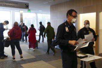 Capital City Fire/Rescue Capt. Roy Johnston talks to people arriving at Juneau International Airport on Saturday, March 21, 2020 in Juneau, Alaska.