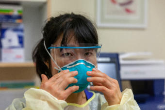 Katie Church, an RN at Bartlett Regional Hospital, demonstrates putting on personal protective equipment to handle a patient infected with COVID-19 on Monday, April 7, 2020 in Juneau, Alaska. (Photo by Rashah McChesney/KTOO)