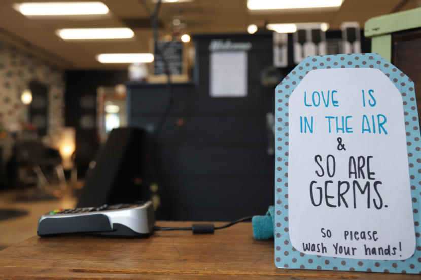 A sign that says "Love is in the air, and so are germs, so please wash your hands!"